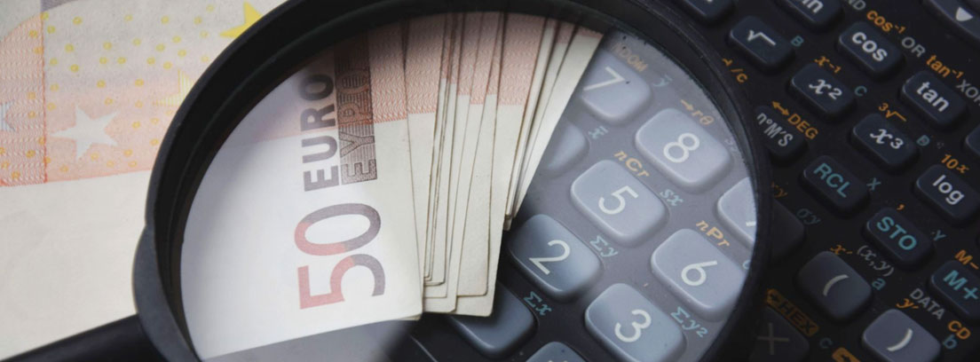 Indemnización por despido improcedente Bajo lupa calculadora y billetes de 50 euros
